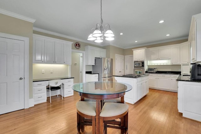 kitchen featuring light wood-type flooring, stainless steel appliances, decorative light fixtures, an inviting chandelier, and white cabinetry