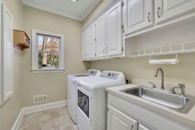 laundry area featuring crown molding, cabinets, sink, and washer and dryer