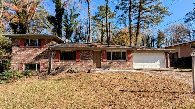 split level home featuring a garage and a front lawn