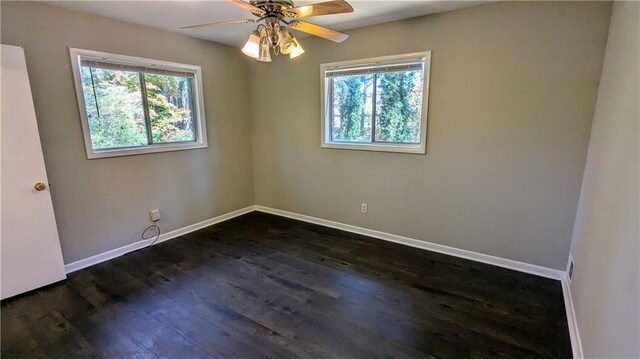 spare room with dark hardwood / wood-style floors, plenty of natural light, and ceiling fan