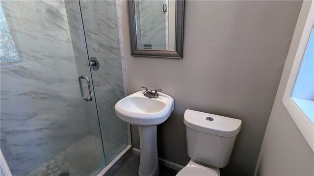 bathroom with toilet and a shower with shower door