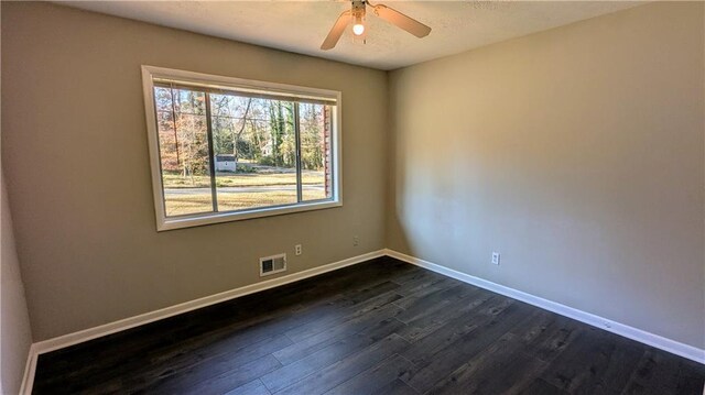 spare room featuring ceiling fan and dark wood-type flooring