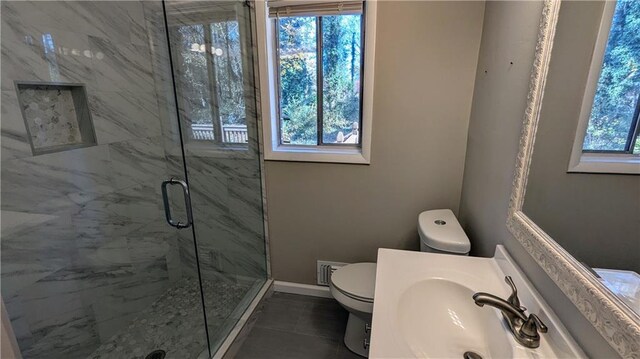 bathroom with tile patterned floors, toilet, an enclosed shower, and sink