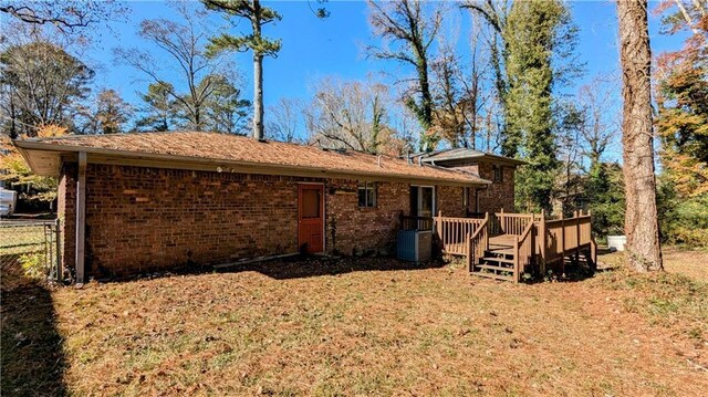 back of house with central AC unit and a wooden deck