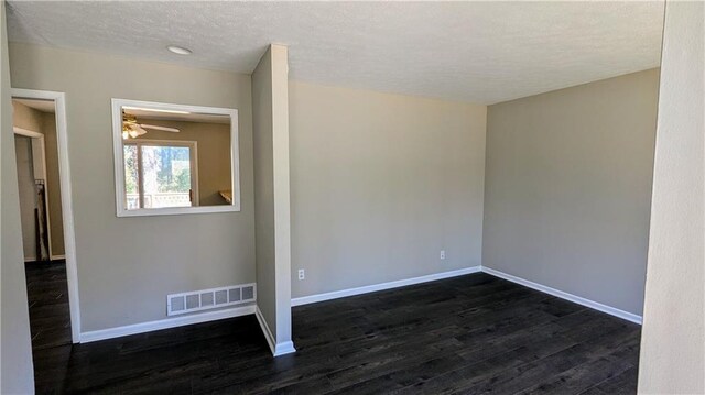 spare room featuring a textured ceiling, ceiling fan, and dark wood-type flooring