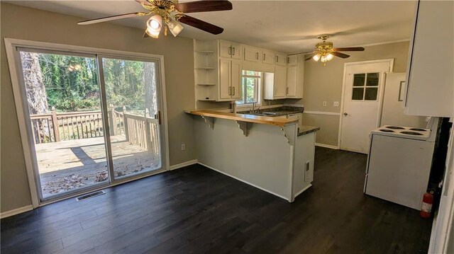 kitchen with kitchen peninsula, a breakfast bar, white cabinets, and a healthy amount of sunlight