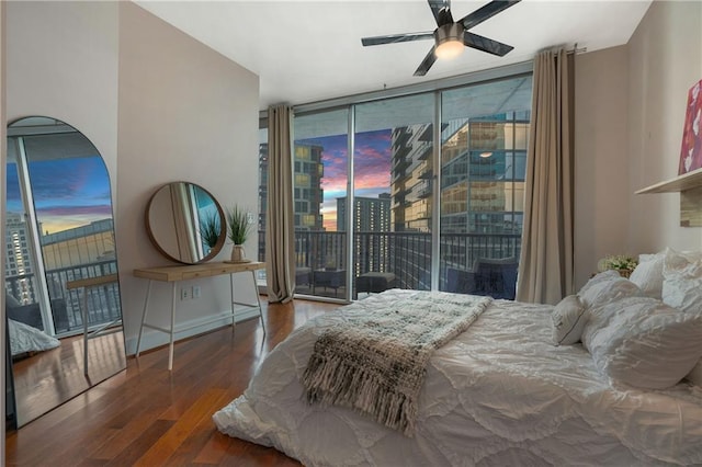 bedroom featuring expansive windows, dark hardwood / wood-style floors, access to exterior, and ceiling fan