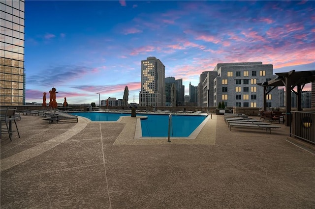 pool at dusk with a patio area