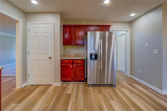 kitchen featuring stainless steel fridge with ice dispenser, a textured ceiling, and light wood-type flooring