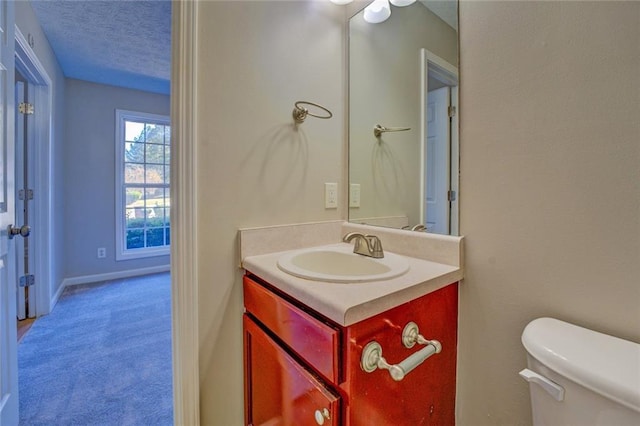 bathroom featuring vanity, a textured ceiling, and toilet