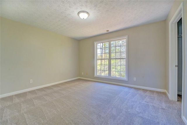 carpeted spare room featuring a textured ceiling