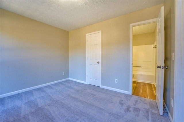 unfurnished bedroom featuring carpet and a textured ceiling