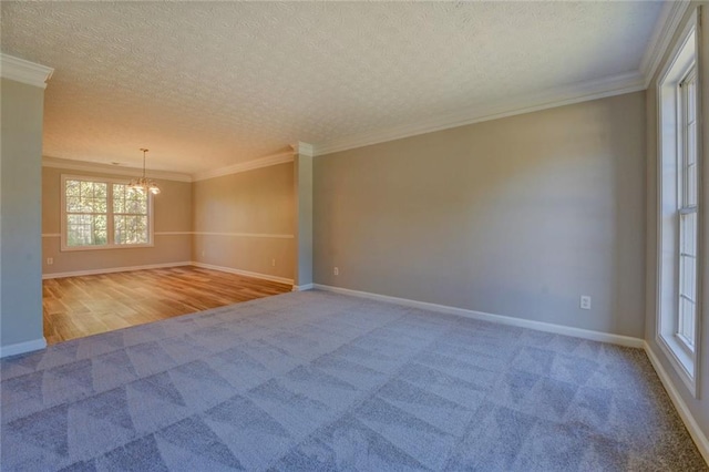 unfurnished room featuring ornamental molding, a textured ceiling, light carpet, and an inviting chandelier