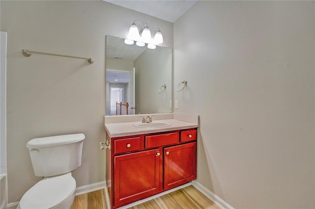 bathroom with wood-type flooring, vanity, and toilet