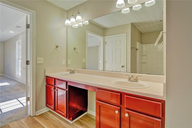 bathroom with walk in shower, vanity, a notable chandelier, and hardwood / wood-style flooring