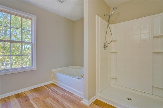 bathroom with plus walk in shower and wood-type flooring