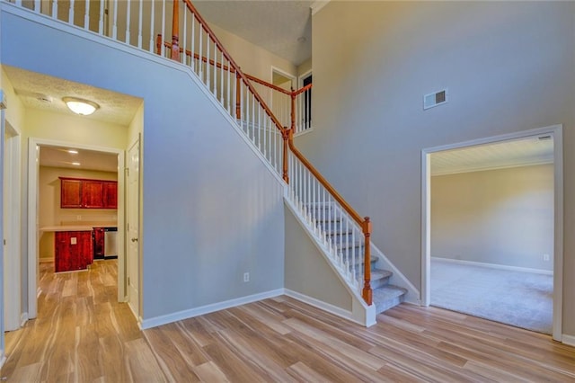 stairway featuring hardwood / wood-style floors and a towering ceiling