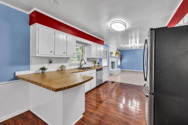 2648 Oswood Dr, Tucker, GA 30084 - kitchen featuring appliances with stainless steel finishes, a sink, a peninsula, dark wood-style flooring, and crown molding