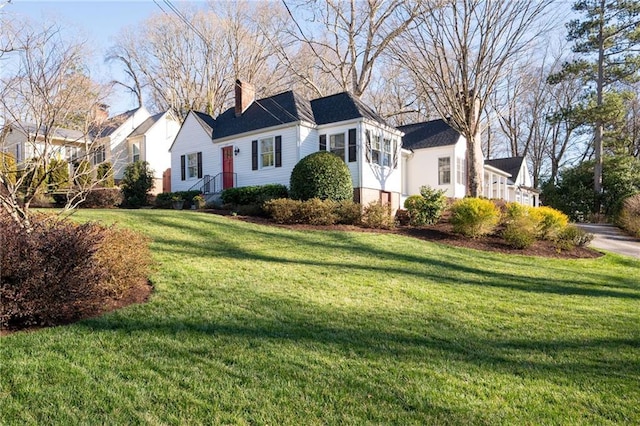 view of front of property with a chimney and a front lawn