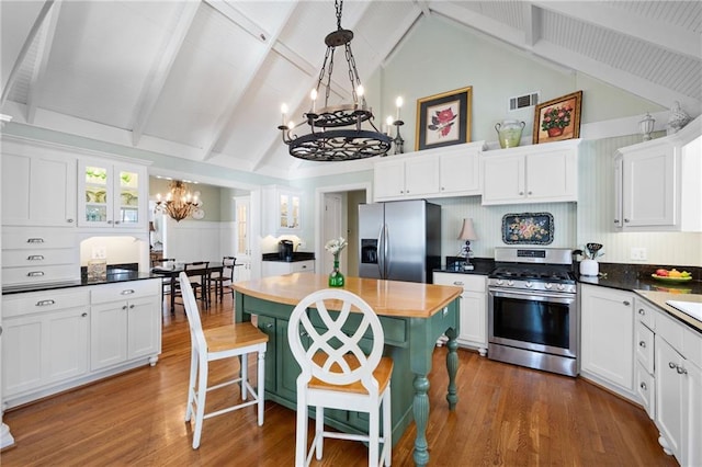 kitchen featuring appliances with stainless steel finishes, white cabinetry, visible vents, and an inviting chandelier