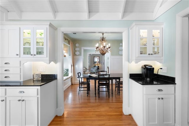 kitchen with glass insert cabinets, light wood-type flooring, and white cabinetry