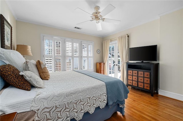 bedroom featuring baseboards, visible vents, ceiling fan, wood finished floors, and crown molding