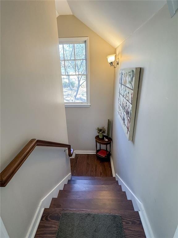 stairs featuring vaulted ceiling, baseboards, and wood finished floors