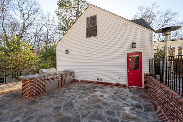 exterior space featuring a grill, fence, a sink, and area for grilling