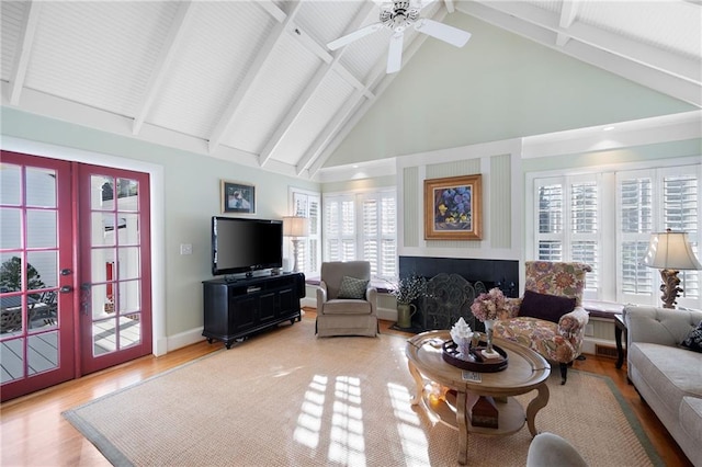 living area with a healthy amount of sunlight, light wood-style floors, baseboards, and french doors