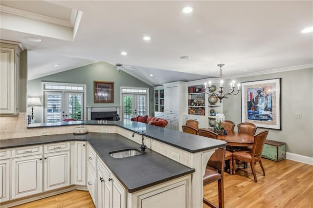 kitchen with sink, french doors, pendant lighting, and kitchen peninsula