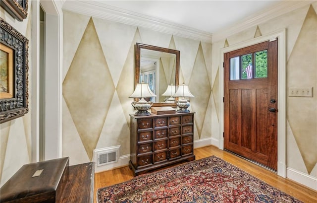 foyer entrance featuring light hardwood / wood-style floors and crown molding