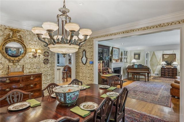 dining space featuring a chandelier, ornamental molding, and hardwood / wood-style flooring