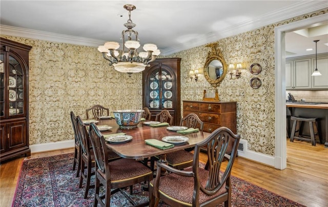 dining room featuring hardwood / wood-style flooring, a notable chandelier, and ornamental molding