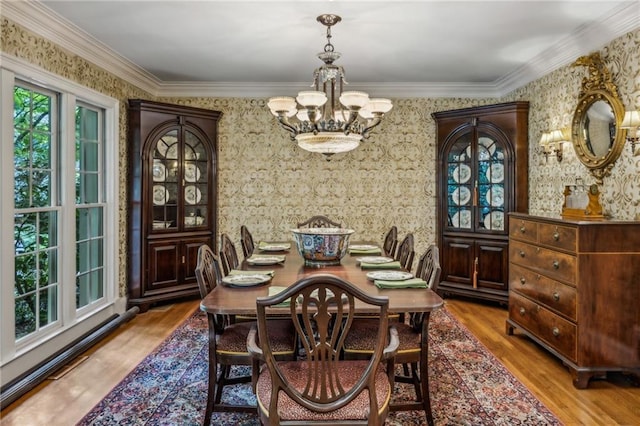 dining room featuring hardwood / wood-style flooring, an inviting chandelier, and crown molding