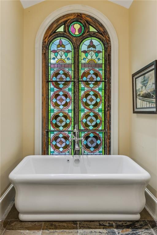 bathroom with lofted ceiling and a tub to relax in