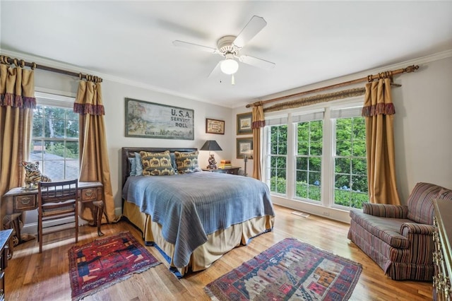 bedroom featuring ceiling fan, hardwood / wood-style flooring, and crown molding