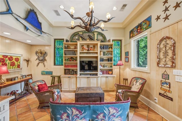 living area featuring a notable chandelier, wood walls, and light tile patterned floors