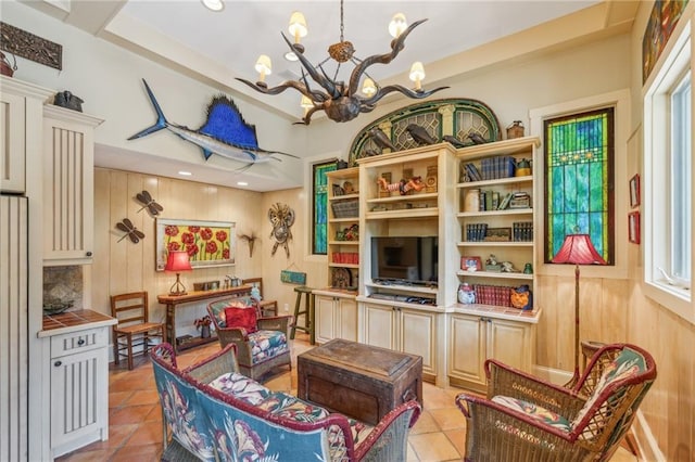 living room with an inviting chandelier, wood walls, and light tile patterned floors