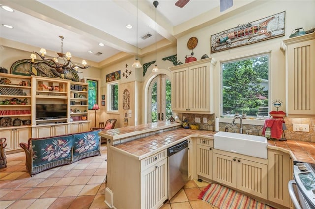 kitchen with sink, dishwasher, kitchen peninsula, tile counters, and pendant lighting