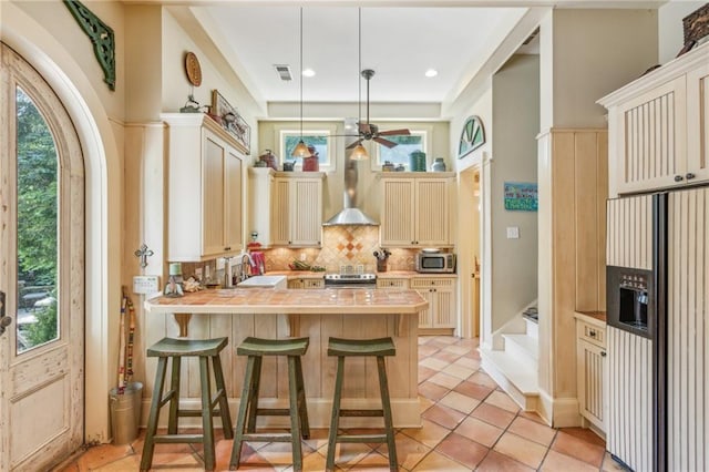 kitchen with hanging light fixtures, stainless steel appliances, backsplash, a breakfast bar area, and sink