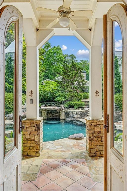 view of pool featuring pool water feature, a patio area, and ceiling fan