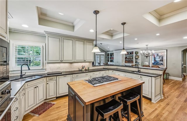 kitchen featuring sink, kitchen peninsula, hanging light fixtures, and a center island