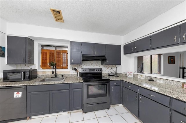 kitchen featuring sink, gray cabinets, light tile patterned floors, a textured ceiling, and stainless steel appliances