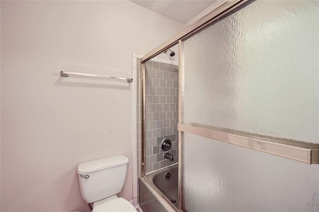 bathroom with bath / shower combo with glass door and toilet