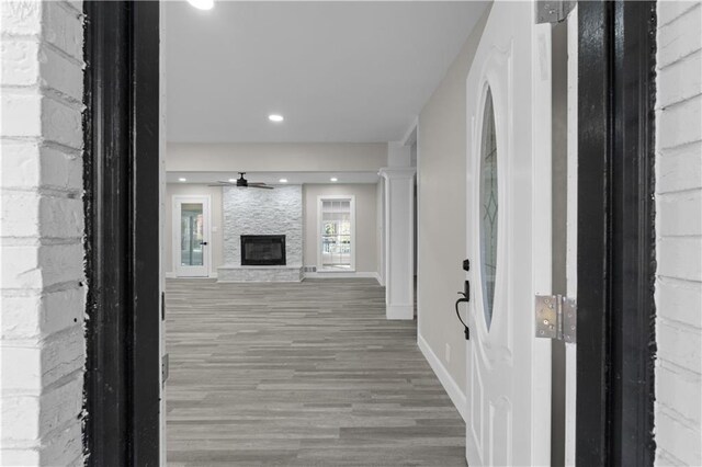 hallway featuring wood-type flooring and ornate columns