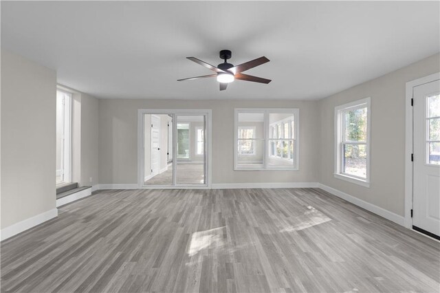 unfurnished living room with ceiling fan, light hardwood / wood-style flooring, and a baseboard heating unit