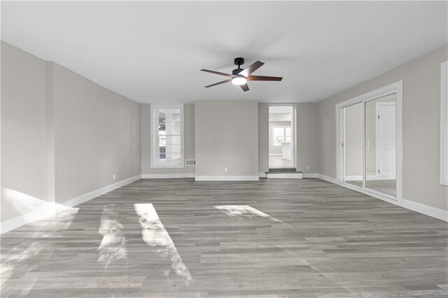 unfurnished room featuring light hardwood / wood-style floors, a wealth of natural light, and ceiling fan