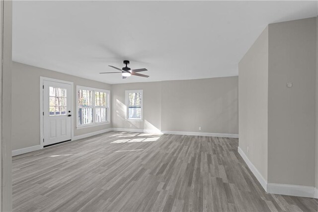 unfurnished living room featuring ceiling fan and light hardwood / wood-style floors