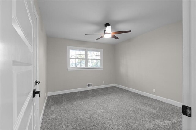 carpeted spare room featuring ceiling fan