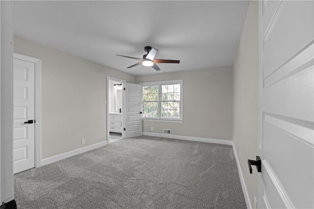 unfurnished bedroom with connected bathroom, carpet floors, and ceiling fan